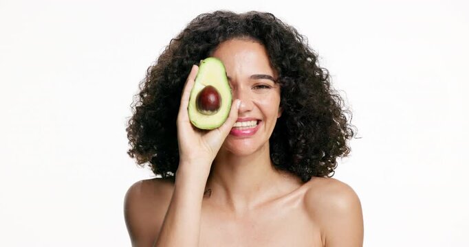 Happy woman, face and avocado with skincare in studio for skin nutrition on a white background. Portrait, female person or model with smile or natural organic fruit for health, vitamin or antioxidant