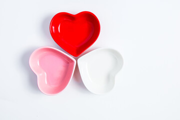 Heart shaped bowls in red pink and white arranged on a light background for creative displays