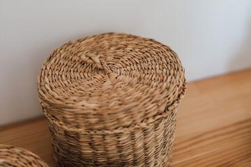 Handmade woven basket placed on wooden surface in cozy room setting