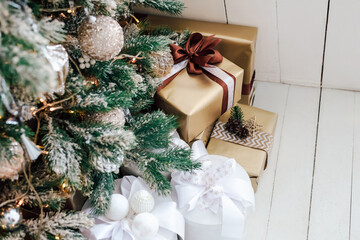 Holiday gifts arranged under a beautifully decorated Christmas tree in a cozy room