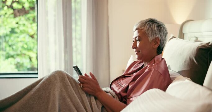 Phone, smile and senior woman in bed with social media, comic or comedy video on the internet. Happy, technology and mature female person in scroll on mobile app with cellphone in home for break