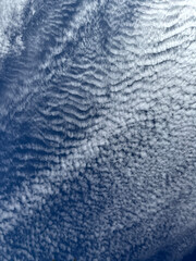 Panoramic pattern of white clouds up in a blue sky