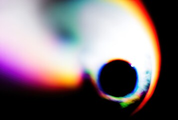 Abstract, blurry, and colorful light forms a surreal shape against a stark black background