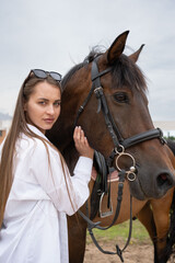 Tender moment between a young woman and a horse in a stable, highlighting a serene and emotional connection.