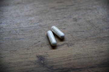 Close-up hand holding two white round pills