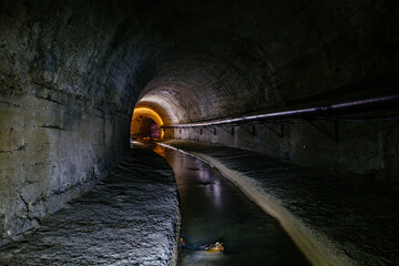 Underground vaulted urban sewer tunnel with dirty sewage