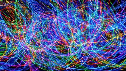 Abstract image of blurred, colorful light trails against a dark background