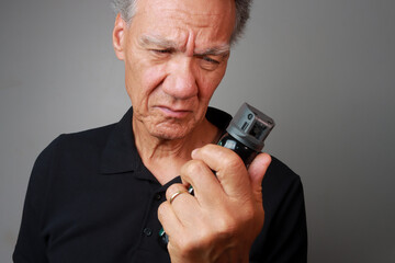 Older Man holding a can of Mace or Pepper Spray for self-protection 