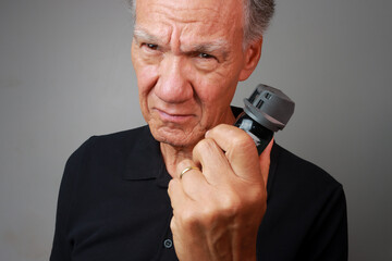 Older Man holding a can of Mace or Pepper Spray for self-protection 