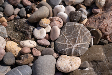 Pebbles, stones, beach, smooth rounded rocks on natural ground providing soothing outdoor environment texture