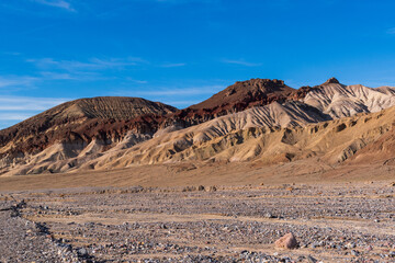 Afternoon Desert Scene with Rocky Wash and Striped Hills Under Deep Blue Sky, Death Valley National Park