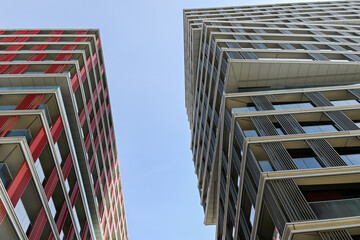 Low-angle view of building facade against a light teal sky, showcasing modern architecture and design, urban, London, United Kingdom, 8 March 2025