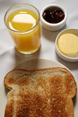 Toast and orange juice served with jam and butter for a simple breakfast. Cotswolds countryside, England