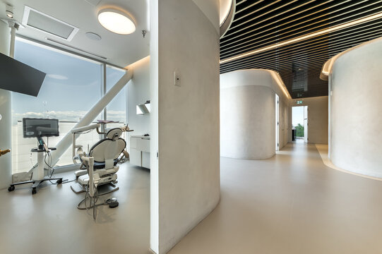 Modern dental office interior with reception desk, patient chairs, treatment rooms and professional equipment. Bright clean environment designed for healthcare and dentistry services, including x-ray 