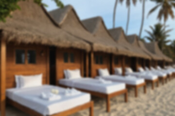 Obraz premium blurry background of white sand beach with wooden houses and sun beds for visitors.