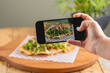 Person taking photo of nachos with smartphone in Costa Rica