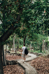 A man walking along a winding path in a wooded area.