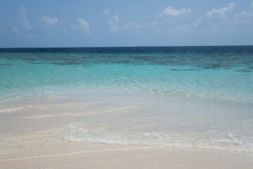 Turquoise tropical sea with gentle waves on sandy beach