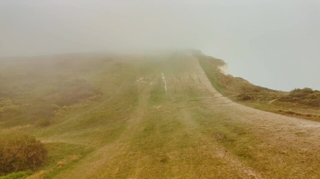 The stunning cliffs of Eastbourne enshrouded in mist, East Sussex, England, UK, with chalk faces fading into low cloud along the Channel coast