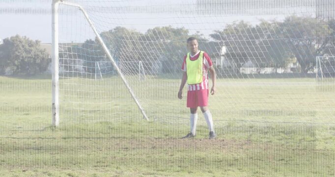Soccer goalkeeper neon vest walking to goal line shuffling and lunging missing and retrieving ball