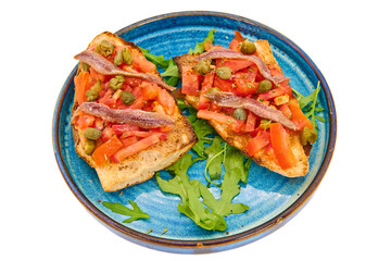 Italian bruschetta with fresh tomatoes, capers, anchovies and crusty bread on a blue plate