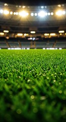 Naklejka premium Green Turf in Stadium: Captivating view of a freshly manicured, vibrant green turf in a large, illuminated stadium setting, evoking the anticipation and excitement of an upcoming match.