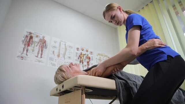 A trained professional demonstrating various therapeutic techniques on a client within a clinical setting environment