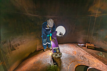 Male worker inspection floor scan tank oil of rust wall, loss of thickness bottom plate in the...