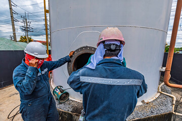 Male worker into the tank carbon chemical oil interface area confined