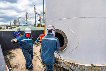 Male worker into the tank carbon chemical oil interface area confined