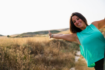 Happy woman leaning out in countryside with arms wide. Lifestyle. Hiking. Bardenas Reales.