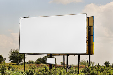 Outdoor advertising construction. billboard on rural area of India, outdoor advertising, mockup billing board in front of green tree and Blank white background for branding design large hoarding.2