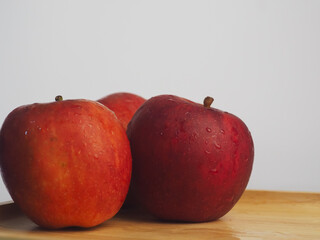 Fresh red apples on a wooden tray, close-up