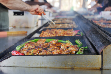 Grilling chicken and vegetables at outdoor market in summer