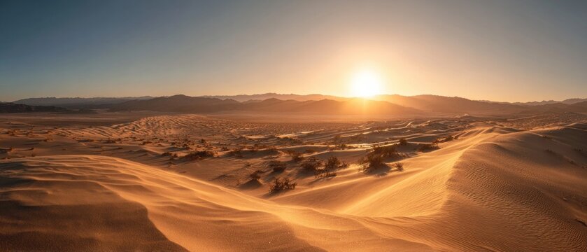 Desert landscape at sunset with dunes and mountains