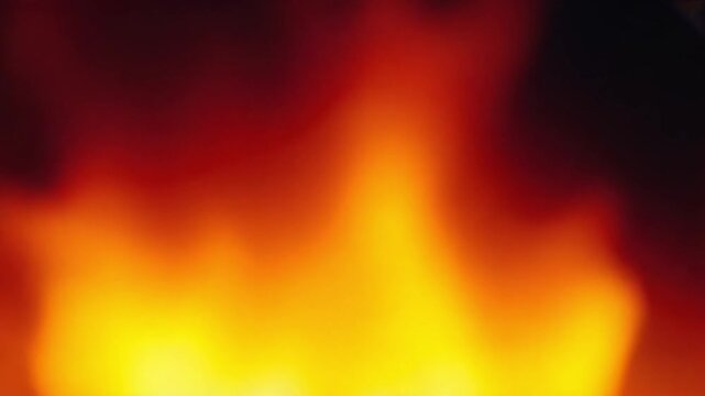 Abstract close up of a bright orange and yellow flame with dark background creating a warm feeling gradient color patterns backgrounds video