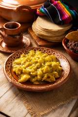 Scrambled eggs in green sauce. A typical Mexican breakfast of scrambled eggs tossed in spicy green sauce, usually accompanied by beans and pot coffee.