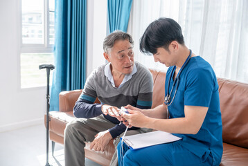 Fototapeta premium male nurse caregiver measuring pulse oximeter to senior man during in a home visit