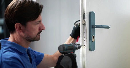 Skilled Locksmith Carefully Installing New Lock On Customer's Front Door