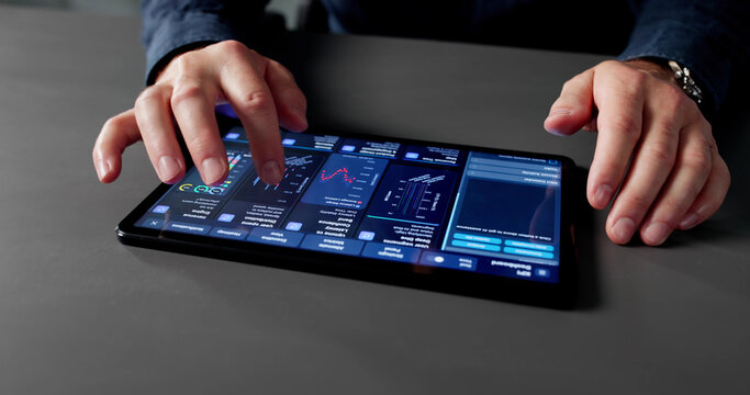 Businessman Analyzing Market Data With Analytic Dashboard - Powered by Adobe