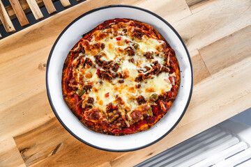 small homemade vegan meat-lover pizza on wooden dining table, healthy vegetarian food