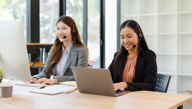 Call center, in headphones. two asian women are working in the office.
 - Powered by Adobe