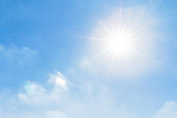Bright sunlight shining in clear blue sky with lens flare and soft clouds, symbolizing freshness, good weather, and natural energy