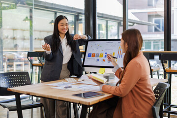 Group of confident business people point to graphs and charts to analyze market data, balance sheet, account, net profit to plan new sales strategies to increase production capacity.	
