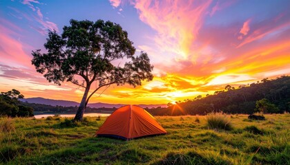 Camping at Sunset with Orange Tent, Green Grassy Meadow, Tall Tree, and Vibrant Red Orange Sky, in Nature's Beauty