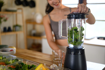 Vibrant wellness scene of a woman blending fresh vegetables for a healthy lifestyle, Focus on blender