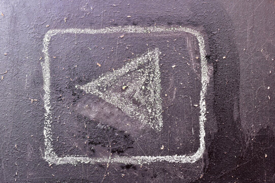 An arrow sign drawn with chalk on a school board.