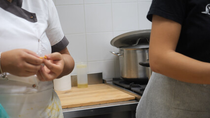 Passionate chefs meticulously crafting pumpkin stuffed fall season tortellini in a cozy professional kitchen creating delicious Italian food with intense focus evident in close-up shots