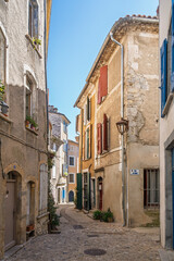 Vertical view of quaint narrow street with colorful shutters in Sauve medieval town, Gard, France