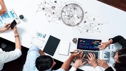 A diverse team engages in a productive brainstorming session on digital strategy, utilizing laptops and charts, highlighting innovation in a collaborative workspace. Raster - Powered by Adobe